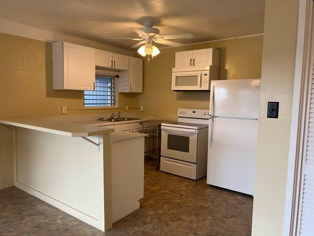 A kitchen with white appliances and a white refrigerator.